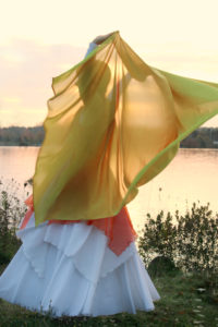 dancer, dancing behind yellow veil in front of water