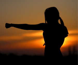 woman in sunset with clenched fist