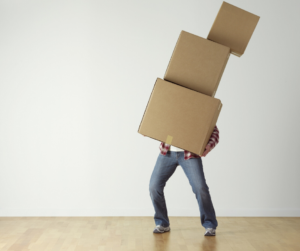 man holding toppling boxes- stuff