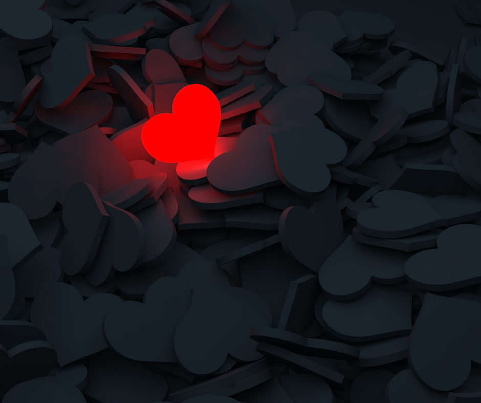 Red heart glowing in midst of dark hearts